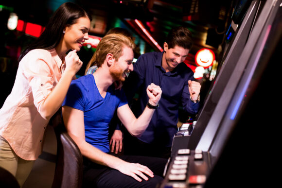 Young people at slot machine in the casino