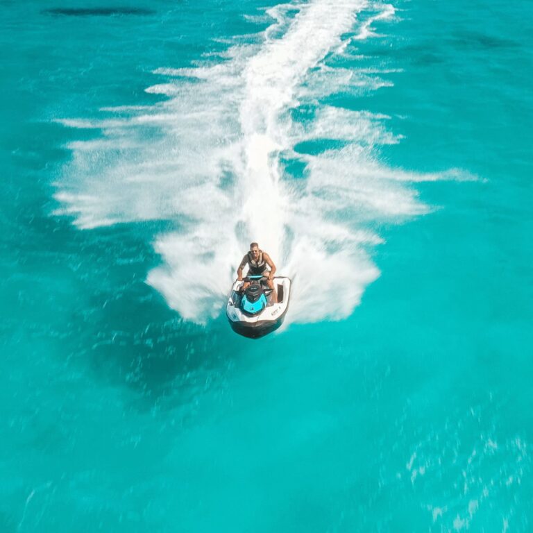 Aerial view of a person riding a jet ski on clear turquoise water